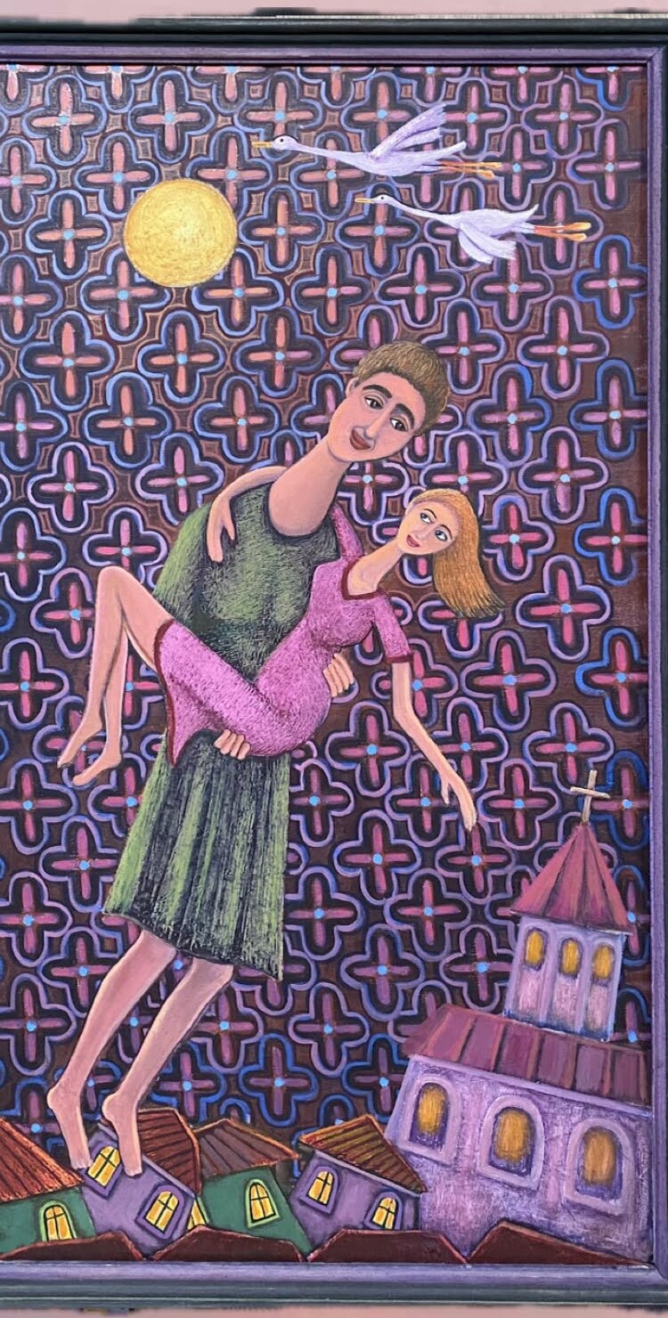 Man carrying woman above village rooftops